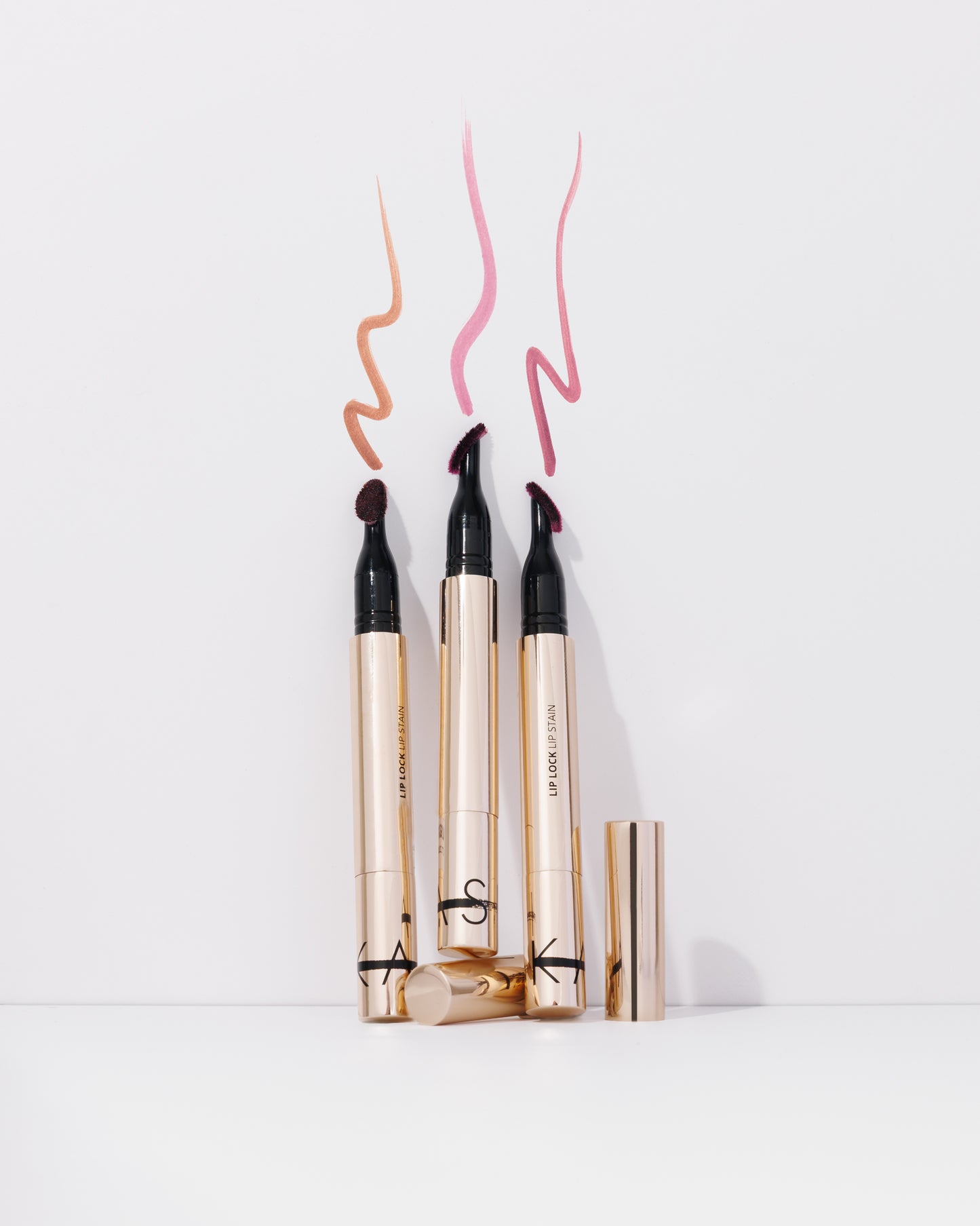 Three lip liner products with color swatches on a white background