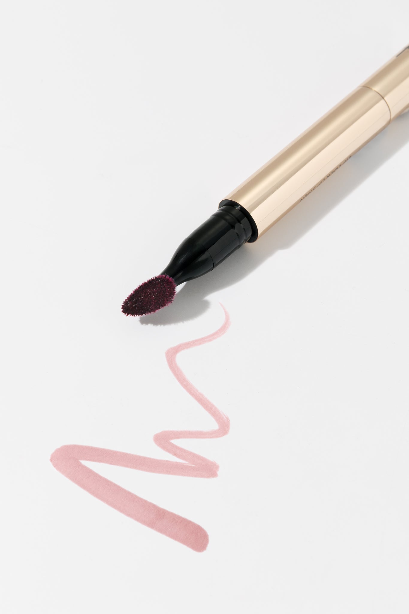 Lip liner with a swatch of pink color on a light gray background