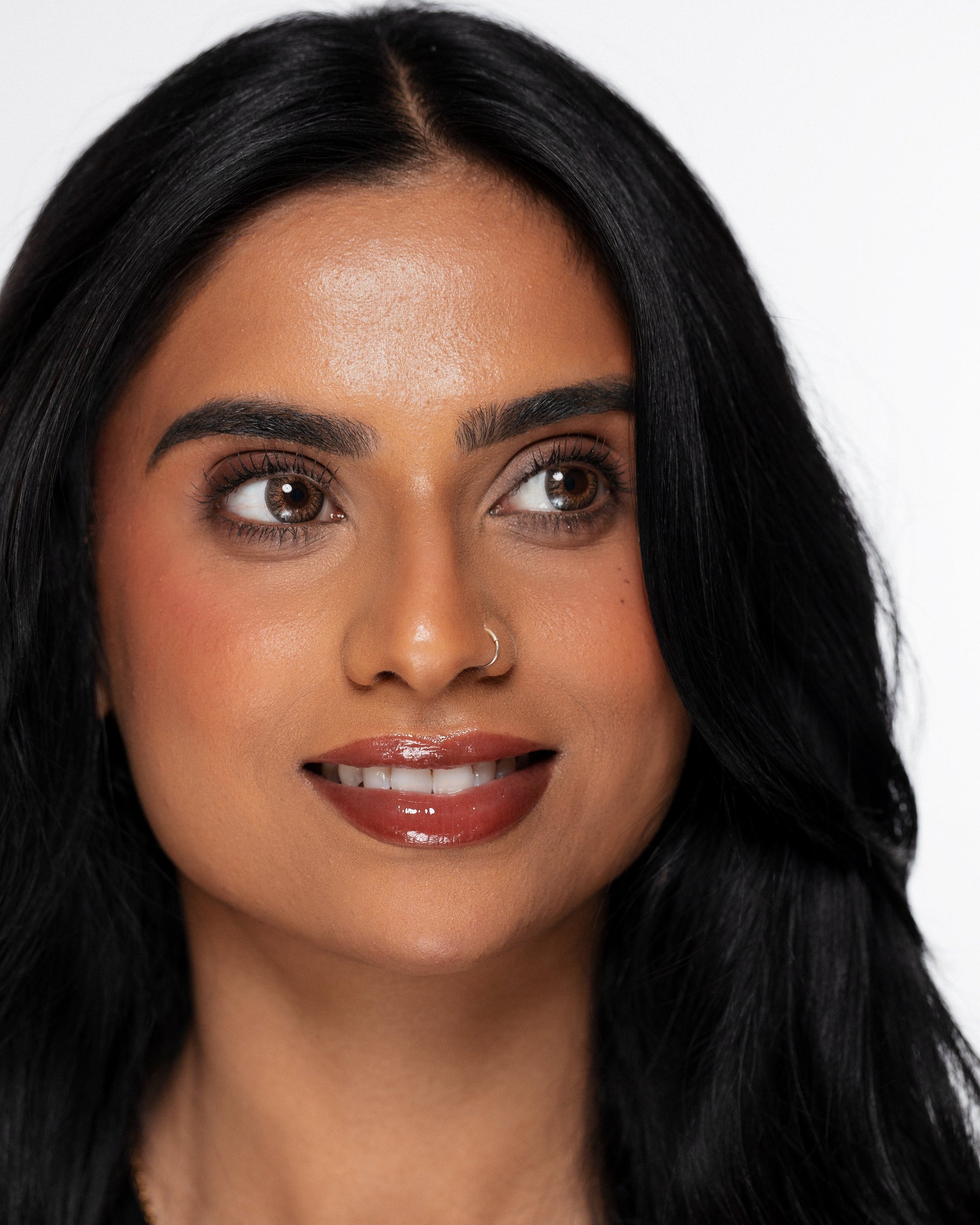 Woman with long black hair and a neutral expression on a white background