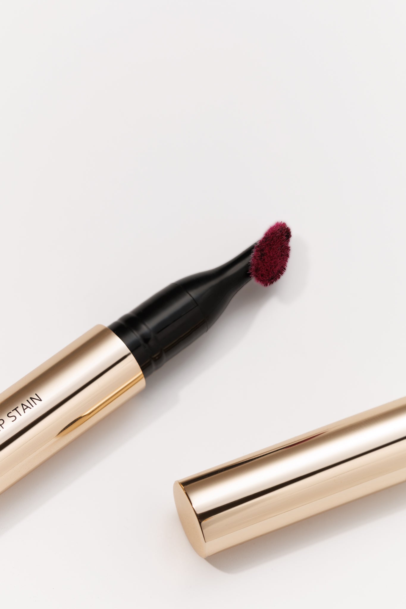 Lip stain pen with applicator on a white background