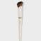 Angled concealer brush with cream handle and soft brown bristles on white background
