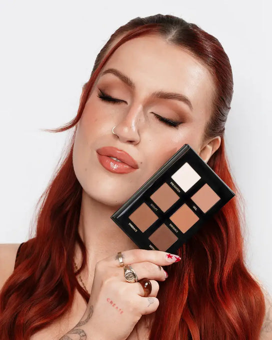 Makeup palette with various shades of brown and beige on a white background